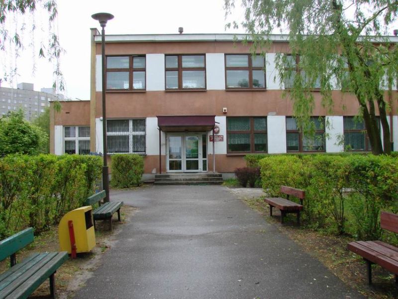 Chodnik i wejście do przedszkola, po lewej i prawej stronie widać ławeczki