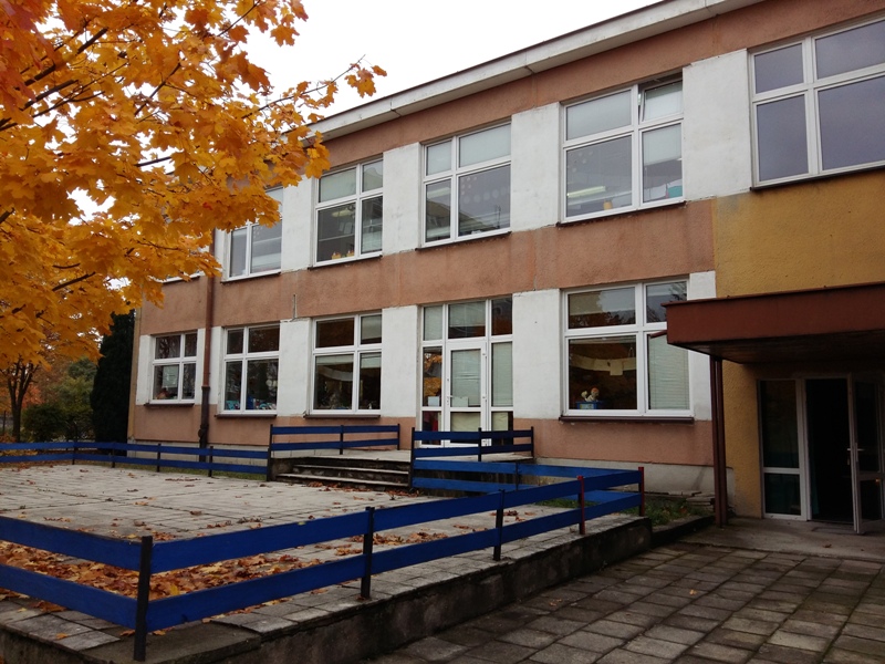 Taras przedszkola z niebieskim płtem z tyłu budynek przedszkola