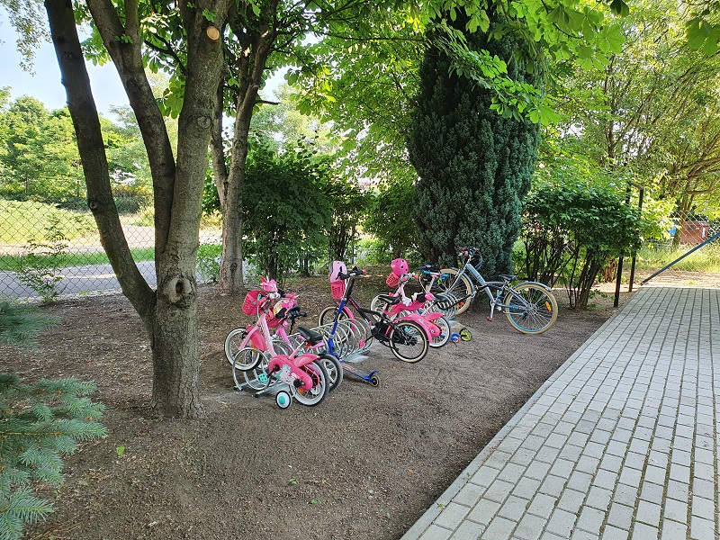 dziecięce rowerki stojące przy stojaku na rowery