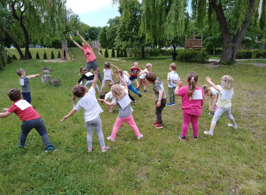 dzieci gimnastykują się na trawie