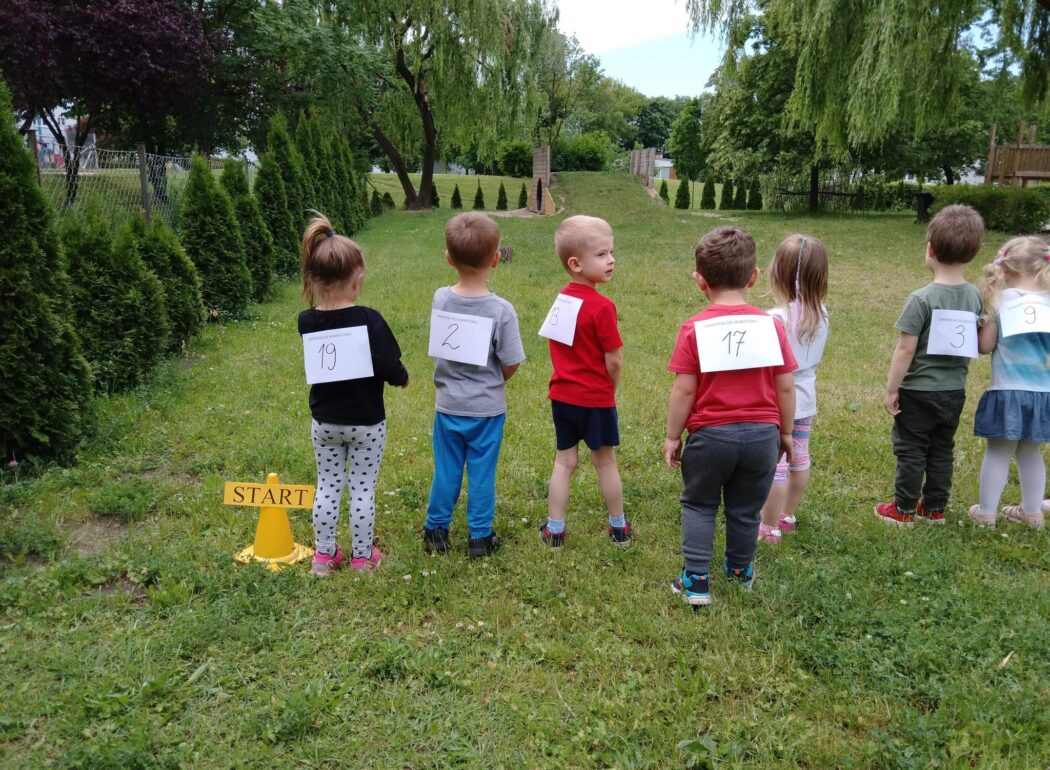 dzieci stoją na trawie