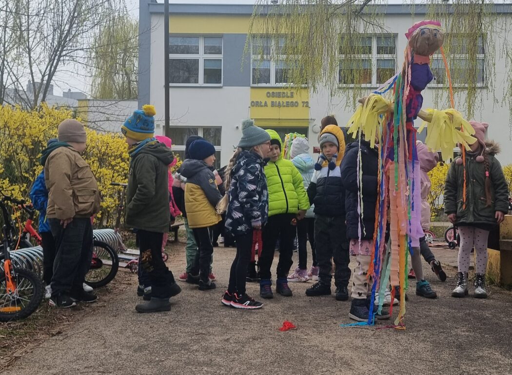 dzieci stoją przed budynkiem przedszkola z marzanną